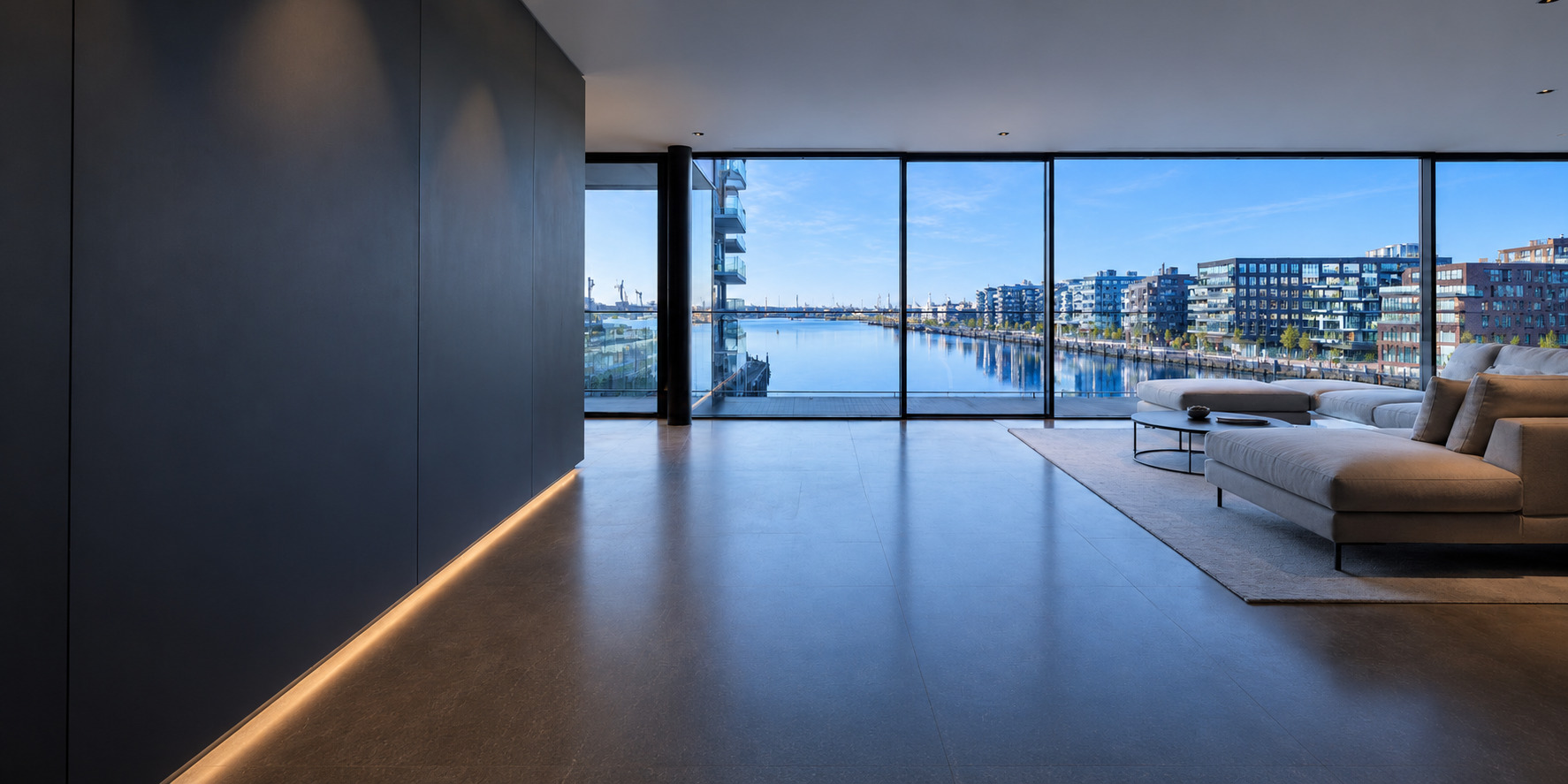 Modernes Wohnzimmer mit bodentiefer Fensterfront und Blick über das Wasser der Hamburger HafenCity