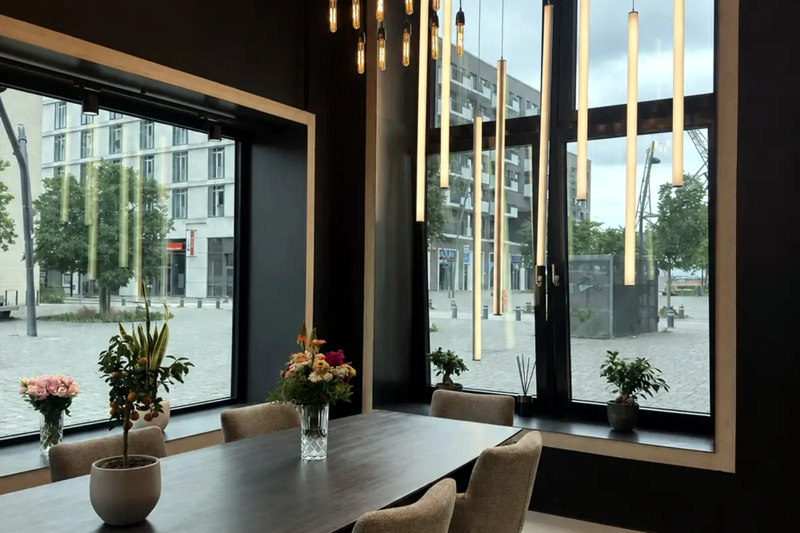 Studio- und Präsentationsbereich mit langem Esstisch und bodentiefen Fenstern zur HafenCity